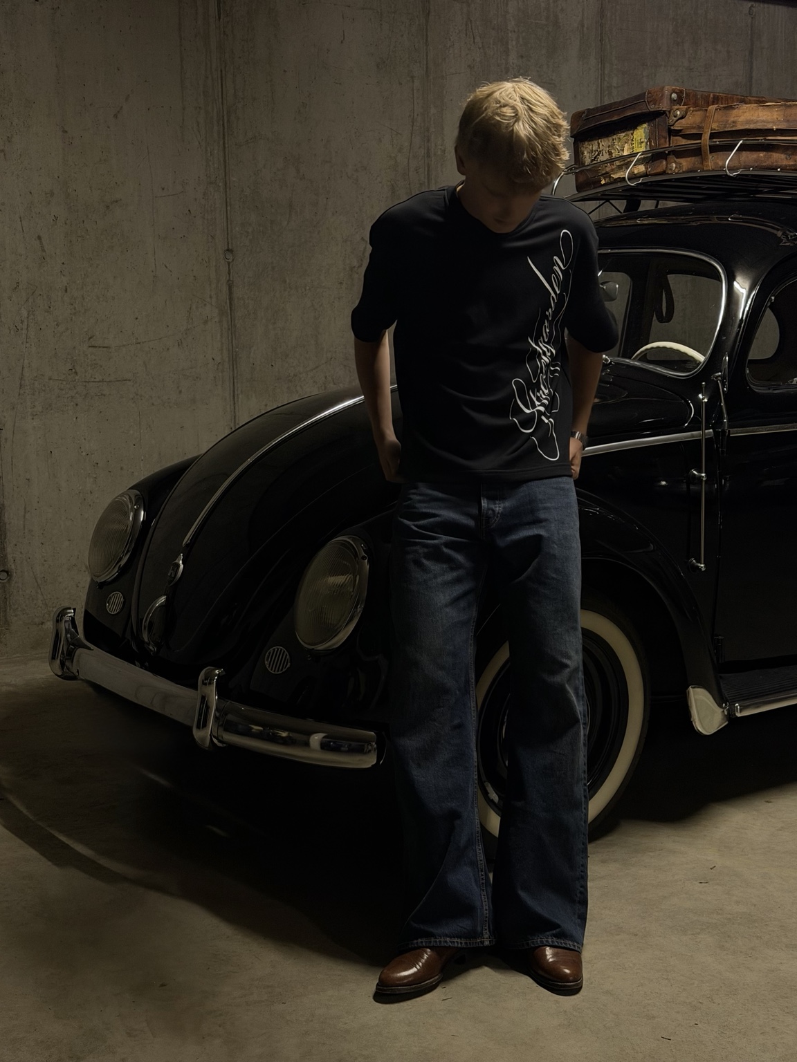 Archive 001 mit dunkler Jeans vor einem Oldtimer